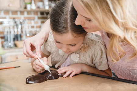Mother and daughter making chocolate rabbitの写真素材