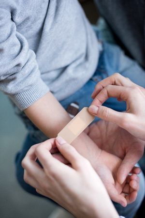 Doctor putting medical patch on handの写真素材