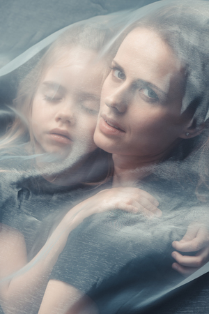 tender daughter and mother hugging with white veilの写真素材