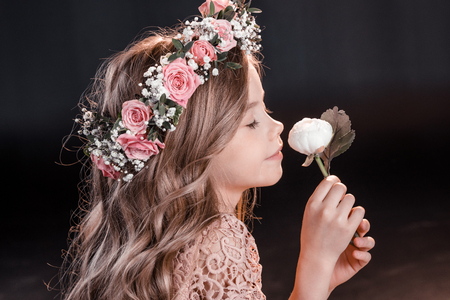 adorable little girl in wreath holding flowerの写真素材