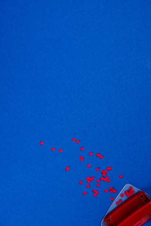 top view of red puncher and paper piecesの写真素材