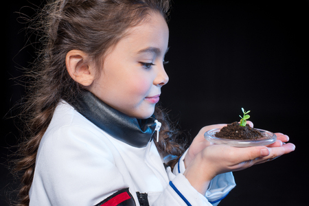 Girl astronaut holding plantの写真素材