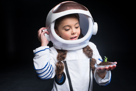 Girl astronaut holding plantの写真素材