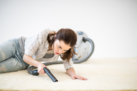 Woman vacuuming carpetの写真素材