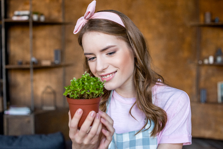 woman holding plant in flowerpotの写真素材