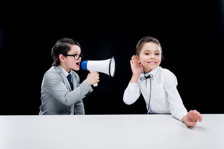 Boy and girl in formal wear interacting with bullhornの写真素材
