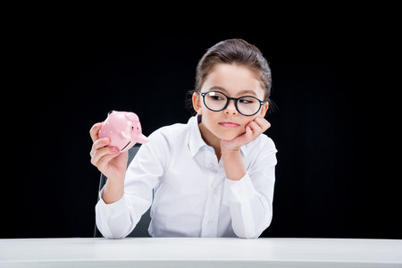 little girl businesswoman holding empty piggy bankの写真素材