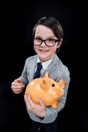 Adorable boy with piggy bankの写真素材