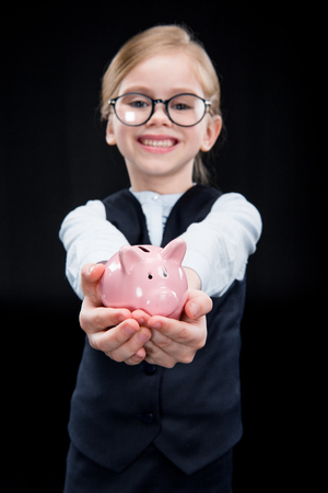 Adorable girl with piggy bankの写真素材