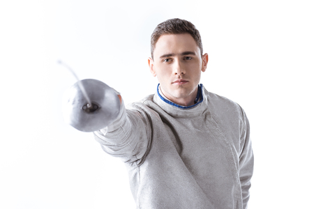 man professional fencer practicing in fencing with rapier on white