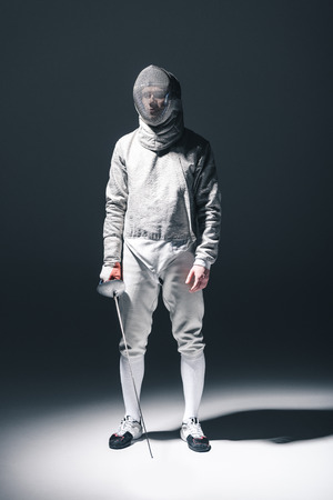 Professional fencer in fencing mask with rapier standingの写真素材