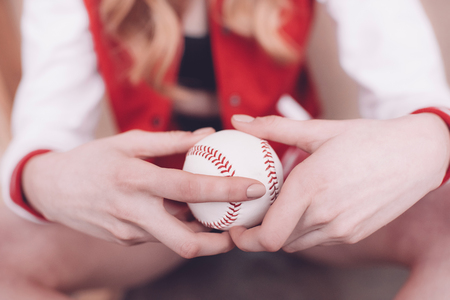 hipster woman holding baseball ball in handsの写真素材