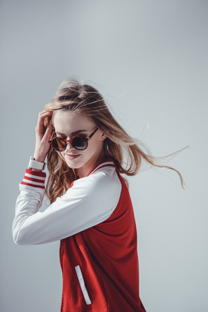 hipster woman with sunglasses posing in studio on greyの写真素材
