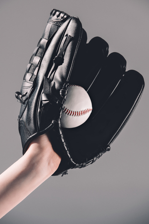 woman in baseball glove holding ball on greyの写真素材