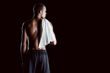 african sporty man with towel on shoulder on blackの写真素材