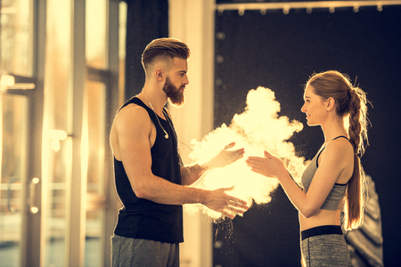 sportsman and sportswoman with chalk powder standing in sports centerの写真素材