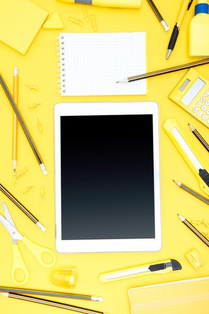 Flat lay of office supplies, digital tablet, notepad and pencilsの写真素材