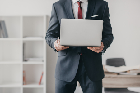 businessman using laptop and standing in officeの写真素材