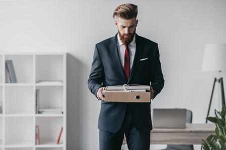 businessman in suit holding documents and folders in officeの写真素材