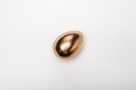 Close-up top view of golden Easter egg on white background, Happy Easter conceptの写真素材