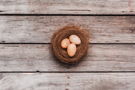 top view of easter eggs in nest on wooden tabletop. Happy Easter conceptの写真素材