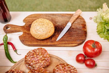 ingredients for hamburgers on table, meat, tomatoes and peppersの写真素材