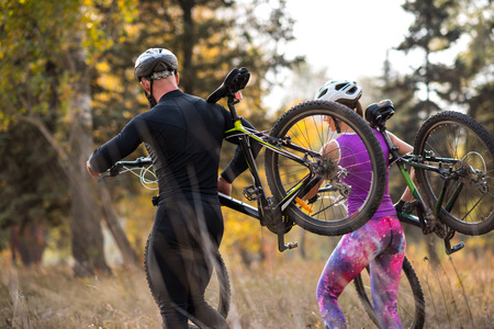Cyclists carrying bikesの写真素材