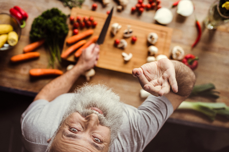 Overhead view of senior man preparing vegan food and showing ok gestureの写真素材