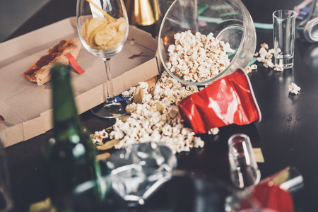 popcorn, glasses and trash on messy table after partyの写真素材