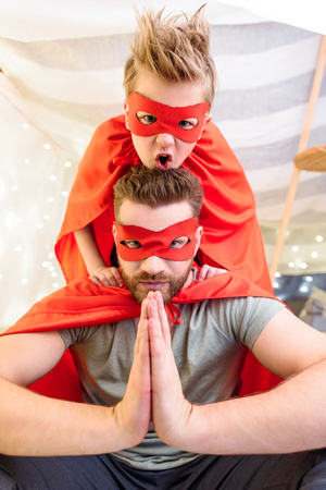 Father and son in superhero costumes playing togetherの写真素材