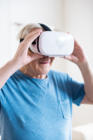 senior man in t-shirt using virtual reality headsetの写真素材