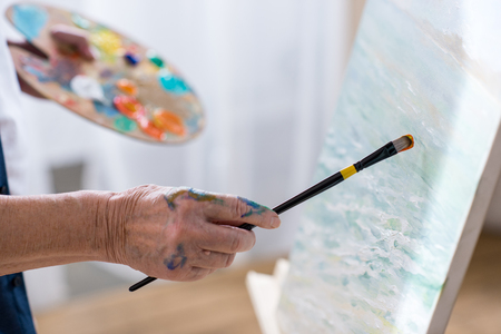 senior man drawing picture in workshopの写真素材