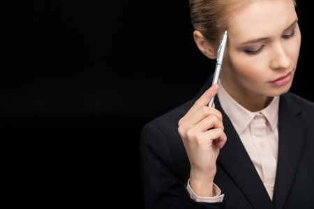 portrait of pensive businesswoman with pen in handの写真素材