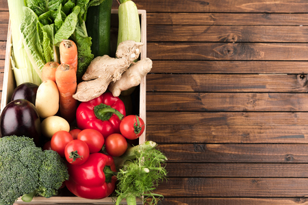 fresh seasonal vegetables in wooden box on wooden table backgroundの写真素材