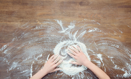 child making pizza dough on wooden tabletopの写真素材
