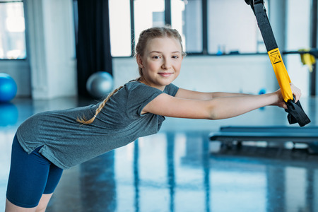 preteen girl training with resistance bands in fitness classの写真素材