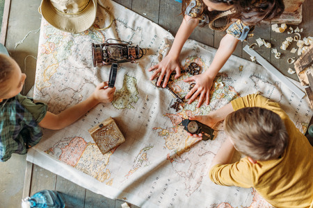 little kids travelers sitting together on porch with map