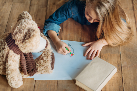 girl drawing picture on floor at home, kids drawing conceptの写真素材