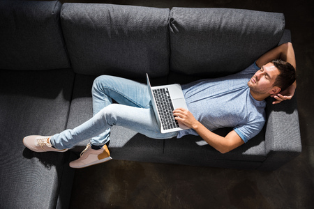 man sleeping on sofa with laptop, small business people conceptの写真素材
