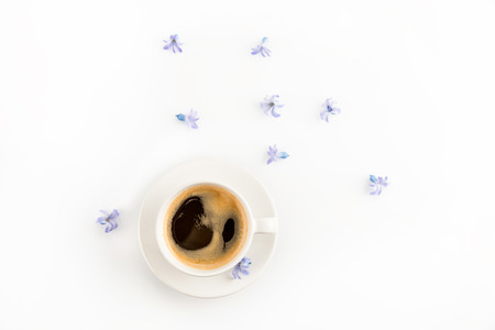Top view of fresh coffee in cup and blue hyacinth flowersの写真素材