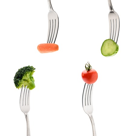 cucumber, cherry tomatoe, carrot and broccoli on forks isolated on white. healthy lifestyle conceptの写真素材