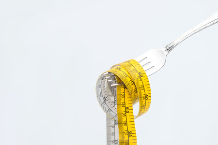 measuring tape on fork isolated on white