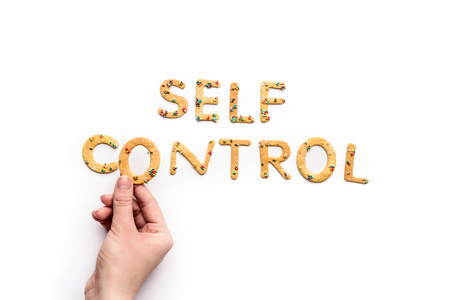 Top view of self control lettering made from sweets and hand holding letterの写真素材