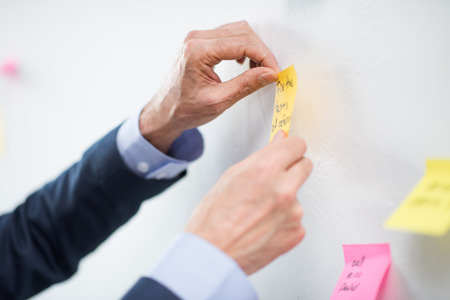businessman putting sticker on boardの写真素材