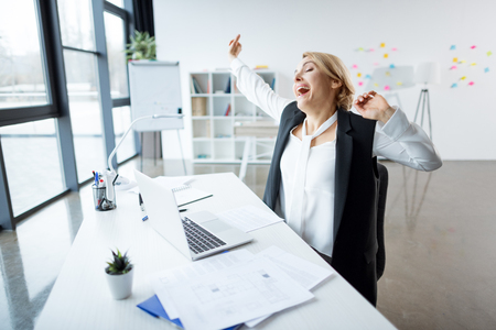 Yawning businesswoman at workplaceの写真素材