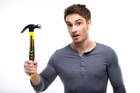 man holding hammer isolated on white, handyman tools conceptの写真素材