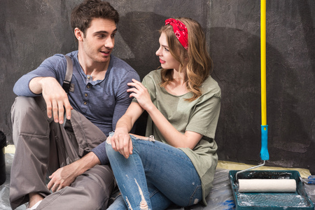 professional couple sitting together on floor and discussing renovation home