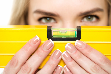 Close-up view of young woman holding level tool in handsの写真素材