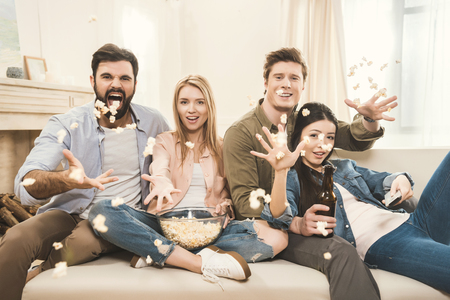 people on couch throwing popcorn upsideの写真素材