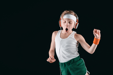 portrait of sportive boy listening music in headphonesの写真素材